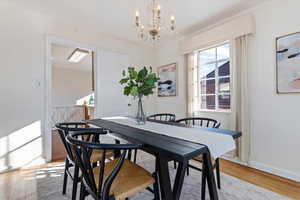 Dining area with a chandelier and light wood flooring