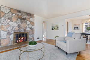 Living room featuring a fireplace, an inviting chandelier, and hardwood / wood  flooring