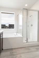 Bathroom with separate shower and tub, vanity, and wood-type flooring