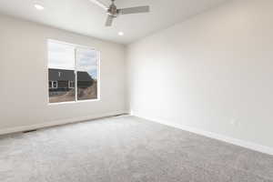 Unfurnished room featuring ceiling fan and carpet floors