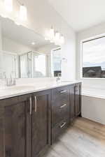 Bathroom with separate shower and tub, vanity, and wood-type flooring