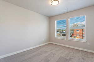 Carpeted spare room with a textured ceiling