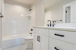 Full bathroom featuring tile patterned flooring, vanity, toilet, and tub / shower combination