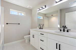 Bathroom featuring vanity, toilet, and a wealth of natural light