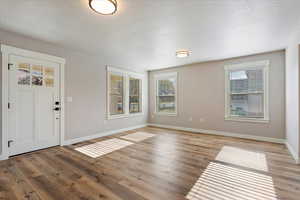 Foyer featuring a textured ceiling and light hardwood / wood-style flooring