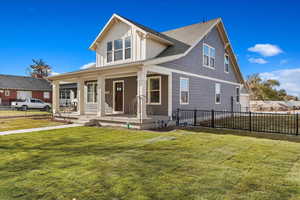 View of front of house with a porch and a front yard