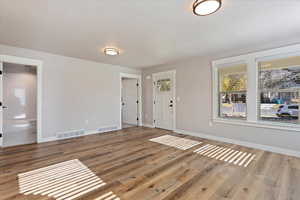 Foyer entrance with hardwood / wood-style floors and a textured ceiling