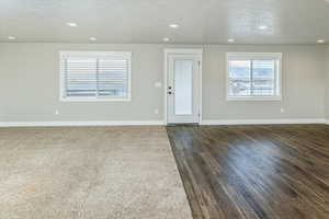 Interior space featuring dark hardwood / wood-style flooring and a textured ceiling