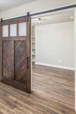 Interior space with a barn door and hardwood / wood-style flooring