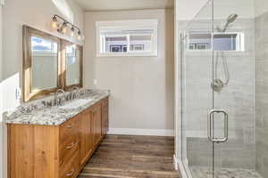 Bathroom with vanity, hardwood / wood-style flooring, and walk in shower