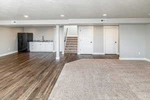 Interior space featuring a textured ceiling, dark wood-type flooring, and sink