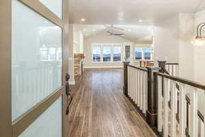 Hallway with dark hardwood / wood-style flooring and lofted ceiling