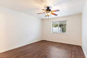 Unfurnished room with dark hardwood / wood-style flooring and ceiling fan