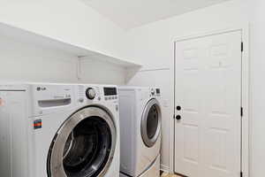 Clothes washing area featuring washing machine and clothes dryer