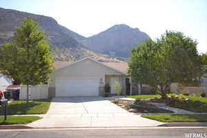 View of front of home with a mountain view, a garage, and a front yard