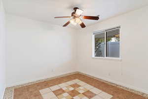 Spare room featuring ceiling fan and light tile patterned floors