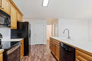 Kitchen featuring hardwood / wood-style floors, sink, and black appliances