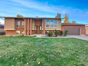 Raised ranch with a garage and a front yard