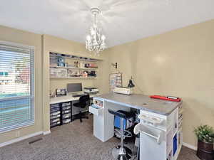 Office space featuring carpet, a textured ceiling, and an inviting chandelier