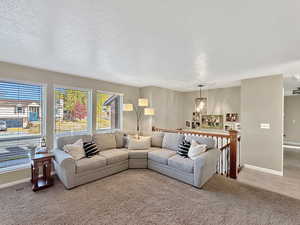 Carpeted living room featuring a textured ceiling