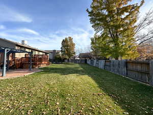 View of yard featuring a pergola, a patio area, and a wooden deck