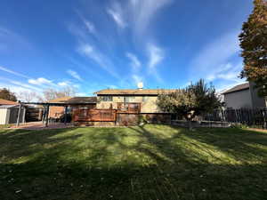 Rear view of property featuring a lawn, a deck, and a pergola