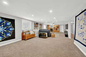 Living room featuring ceiling fan, carpet floors, and a healthy amount of sunlight