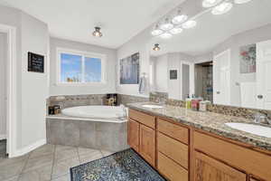 Bathroom with tile patterned floors, vanity, and plus walk in shower