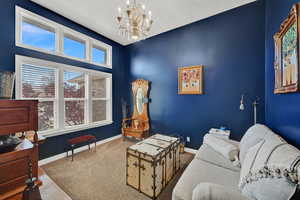 Carpeted living room featuring an inviting chandelier