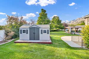 View of outbuilding with a mountain view, a gazebo, and a lawn