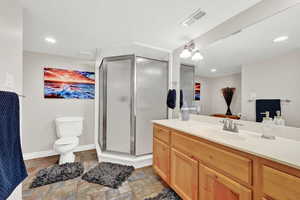 Bathroom with vanity, toilet, and a shower with door