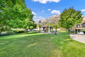 View of yard with a deck with mountain view and a gazebo