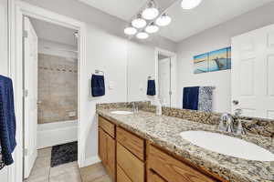 Bathroom featuring tile patterned flooring, vanity, and tiled shower / bath combo