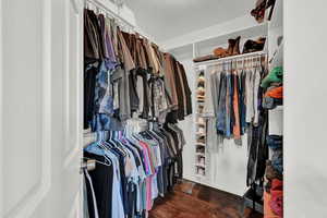 Walk in closet featuring dark wood-type flooring