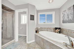 Bathroom featuring tile patterned flooring and shower with separate bathtub