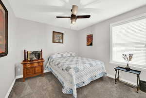 Carpeted bedroom featuring ceiling fan