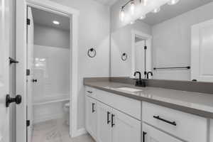 Full bathroom featuring washtub / shower combination, vanity, and toilet