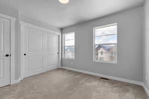 Unfurnished bedroom with light carpet