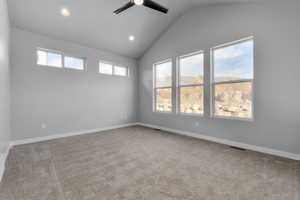 Carpeted empty room featuring ceiling fan, a mountain view, and lofted ceiling