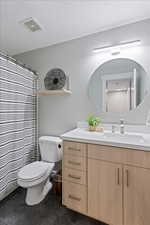 Bathroom with vanity, a textured ceiling, and toilet