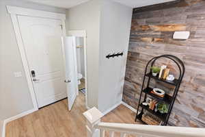 Hall with hardwood / wood-style flooring and wooden walls