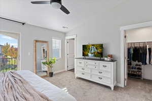 Carpeted bedroom featuring ceiling fan, a spacious closet, lofted ceiling, access to outside, and a closet