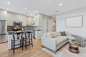 Living room with light wood-type flooring and sink