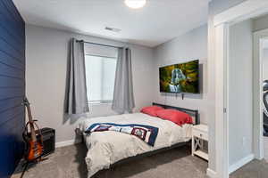 Carpeted bedroom with a textured ceiling