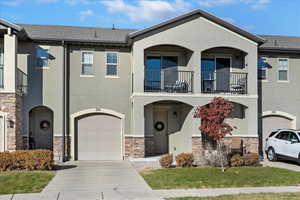 Townhome / multi-family property featuring a balcony and a garage