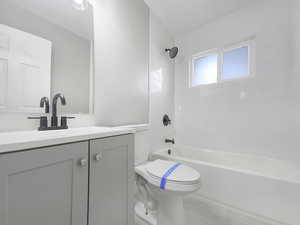 Full bathroom featuring vanity, toilet, and tiled shower / bath