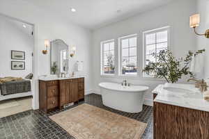 Bathroom featuring vanity, a tub, and vaulted ceiling