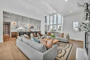 Living room with a high ceiling, light hardwood / wood-style flooring, and a wealth of natural light