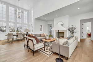 Living room featuring light hardwood / wood-style floors, a high ceiling, and a chandelier