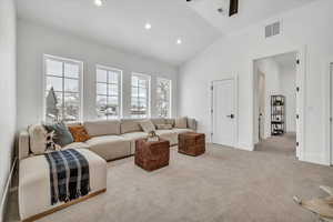 Living room with lofted ceiling and light carpet